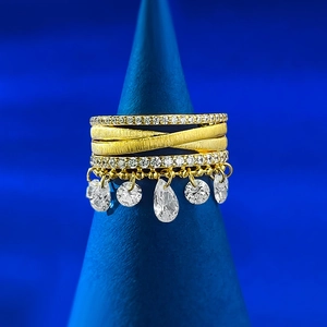 Close-up of gold-plated multi-layer ring with sparkling tassels and brushed finish texture
