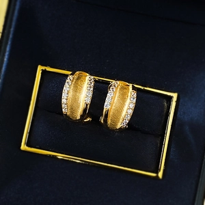 Close-up of brushed gold S925 silver hoop earrings with micro-pave cubic zirconia stones