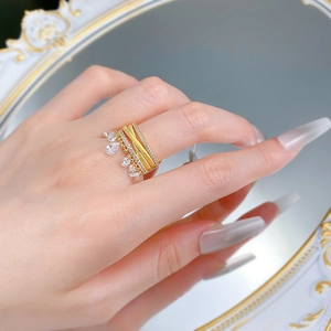 Detail of gold layered ring with sparkling tassels and teardrop-shaped zircon drop charms