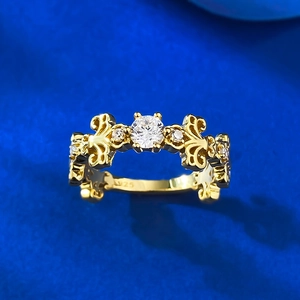 Macro shot of S925 gilded gold ring with fleur-de-lis pattern and sparkling central diamond