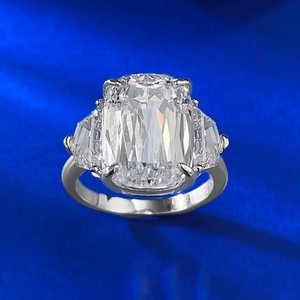 Detail of three-stone S925 silver ring with 10x14mm radiant cut stone on blue background