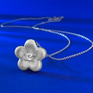 Brushed S925 silver flower pendant necklace with central zircon on blue background