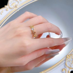 Close-up of S925 silver iris openwork ring with gold plating and white crystals on finger