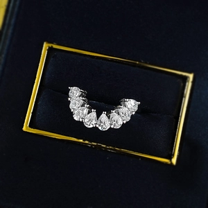 Macro detail of curved pear-cut diamond stacking ring in a blue velvet jewelry box