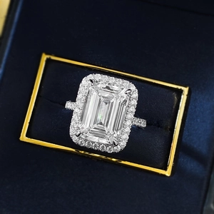 Anello halo taglio smeraldo con fascia pavé in una lussuosa scatola di velluto blu