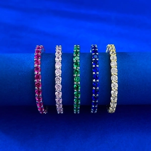 Macro shot of five S925 silver eternity bands with colorful round-cut gemstones