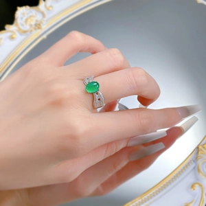 Détail de la bague en agate verte avec anneau pavé ondulé sur le doigt
