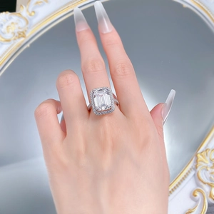 Dettaglio macro dell'anello con pietra taglio smeraldo e pavé di diamanti sulla fascia