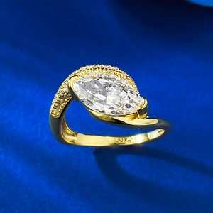 Macro shot of gold-plated S925 silver ring featuring marquise-cut stone and wave band