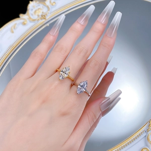 Close-up of gold and silver 925 sterling silver rings with marquise-cut stones on hand