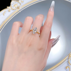 Detailed view of marquise cut diamond ring in 18k gold plating on a model finger