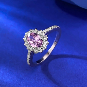 Macro shot of oval pink gemstone ring with halo diamonds and pavé silver band
