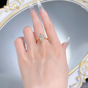 Detailed view of marquise cut diamond ring in gold plating on a model's hand