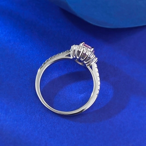 Macro side view of silver ring featuring oval pink stone with diamond pavé accents