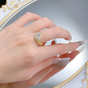 Macro detail of gold marquise cut ring with sparkling accent stones and elegant curved band