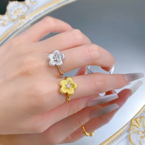 Macro detail of gold and silver floral rings with matte brushed finish and small diamonds