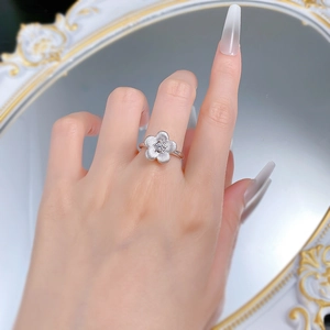 Close-up of S925 silver flower ring with brushed petals and center zircon on finger