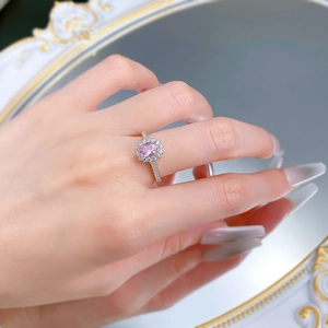 Close-up of S925 silver ring with oval pink gemstone and brilliant halo diamond setting