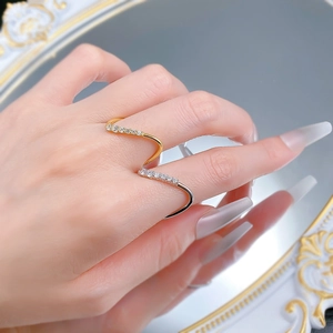 Close-up of wavy gold and silver stackable rings with micro-set crystals on model fingers