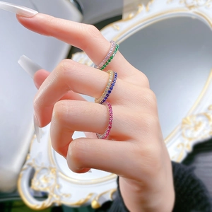 Close-up of minimalist S925 silver rings set with colorful rainbow crystals on finger