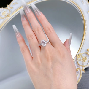 Macro di un anello in argento 925 con diamante ovale e montatura halo sulla mano