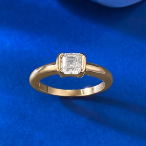 Macro shot of S925 silver ring featuring emerald-cut clear stone and golden band finish