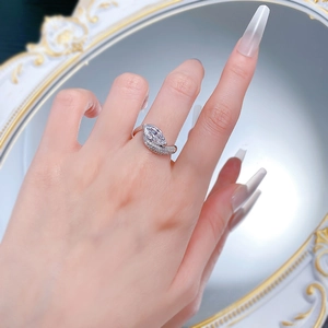 Macro detail of marquise cut diamond ring with pave diamond band on model's hand