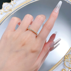 Close-up of a slender gold eternity ring with round-cut sparkling pavé diamonds on finger