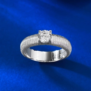 Macro view of S925 silver ring with brushed texture and classic four-prong diamond setting
