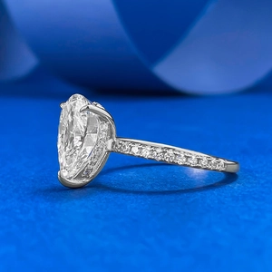 Detailed side view of silver marquise cut ring with crystal pavé on blue texture