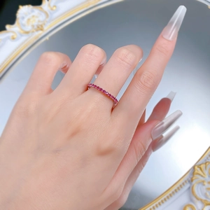 Close-up of a slim S925 silver band set with a row of sparkling red zircon gemstones