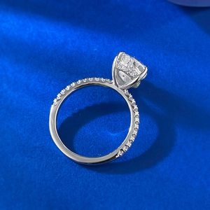Macro detail of S925 silver pear-cut ring with side pavé setting on deep blue texture