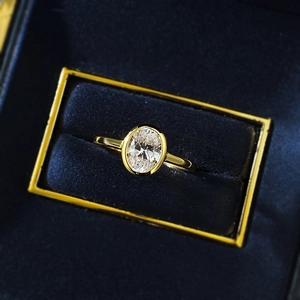 Oval cut faux diamond ring with gold-plated bezel setting in a luxury velvet box