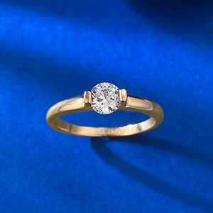 Close-up of golden S925 silver ring with a round white gemstone on blue velvet