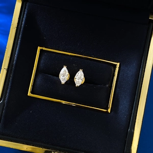 Marquise cut white gemstone stud earrings in gold setting on black velvet box