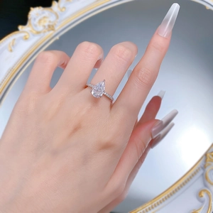 Close-up of S925 silver pear-cut ring on model finger with elegant mirror background