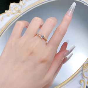 Classic gold round-cut solitaire ring worn by model against an elegant mirror background