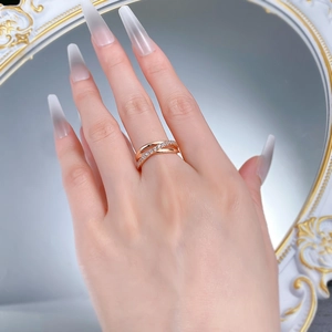 Vue détaillée de la bague croisée en or rose avec zircons scintillants sur la main