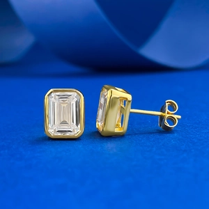 Classic 925 sterling silver emerald cut stud earrings with gold bezel setting on blue silk