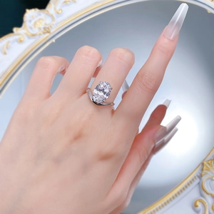 Detailansicht eines Solitär-Ring mit ovalem Diamant am Finger und minimalistischem V-Band