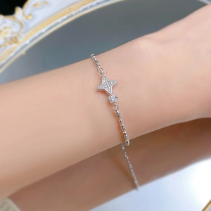 Détail du bracelet en argent S925 avec breloques étoiles brillantes au poignet féminin