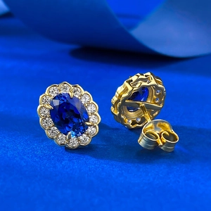 Macro detail of oval royal blue sapphire stud earrings with gold plating and zircon halo