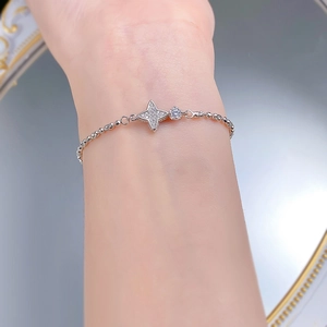 Gros plan du bracelet en argent S925 avec étoile à quatre branches et zircons au poignet