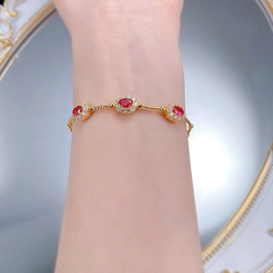 Détail du bracelet en argent S925 avec rubis rouges, chaîne dorée et cristaux brillants