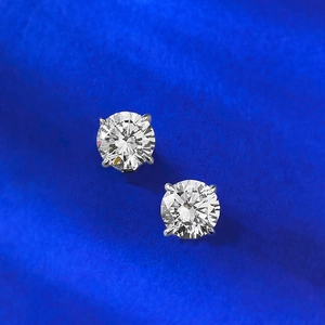 Macro shot of 1 carat round brilliant cut silver stud earrings with classic four-prong setting