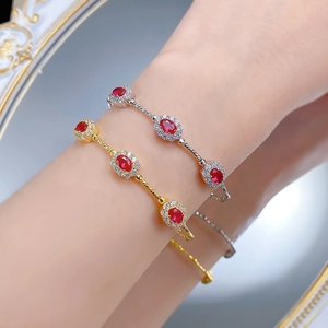 Close-up of elegant gold and silver twisted bracelets with red ruby-colored gemstones