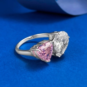 Macro view of bypass ring featuring dual heart-cut pink and white gemstones