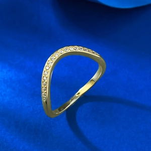 Detail of a wavy gold plated ring featuring a sparkling row of pavé set zircon stones