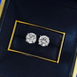 Macro view of classic round cut sterling silver stud earrings in a blue velvet box