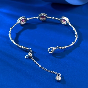 Detailed macro view of S925 silver bracelet featuring three red ruby-colored gemstones